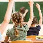 Students raising hands in class